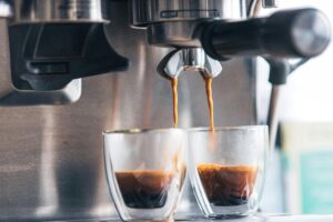 duas xícaras de café enchendo de café